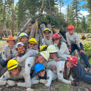 A group of people posing in front of a fire shack.