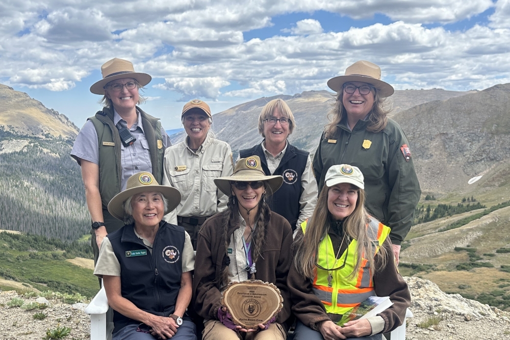 A Rocky Mountain Conservancy naturalist speaks with a group along a park trail.
