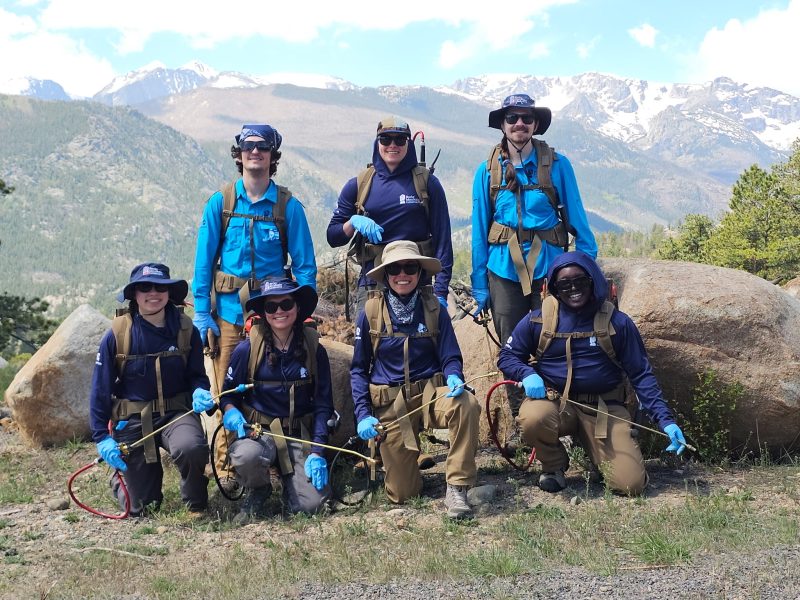 A Rocky Mountain Conservancy conservation crew poses with backpack sprayers in the park.