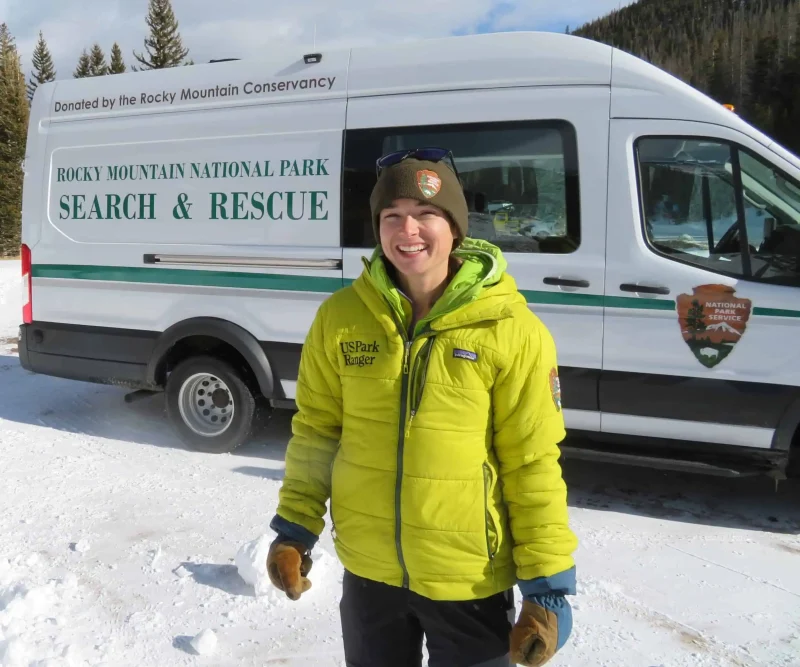 Park ranger standing beside a Rocky Mountain National Park search and rescue vehicle