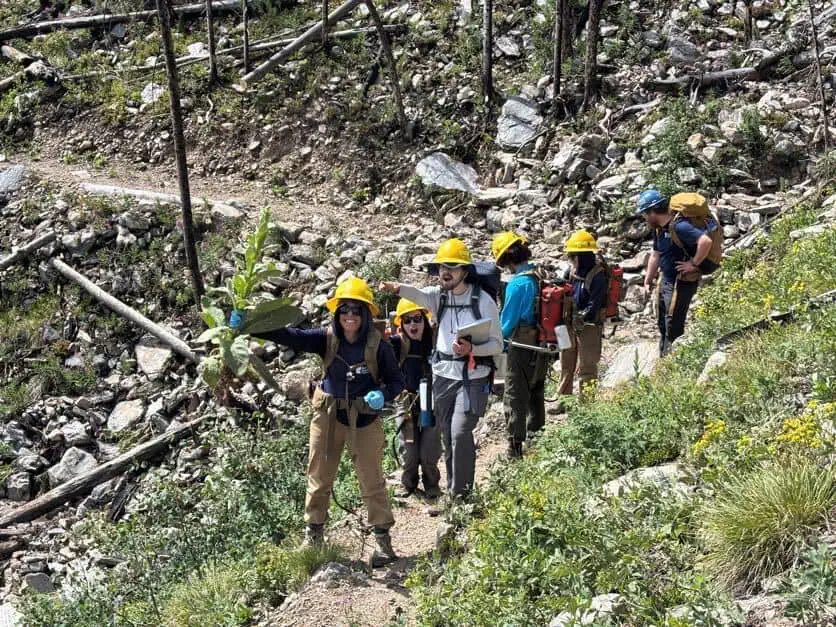 Conservation Corps crew hiking along a steep mountain trail